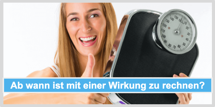 Lächelnde Frau hält eine Waage in der Hand und zeigt Daumen nach oben Black Latte Wirkung